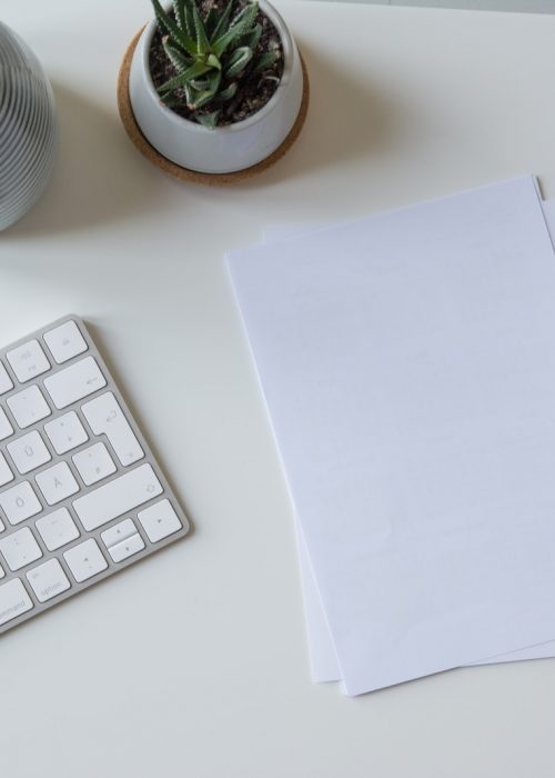 white printer paper beside white apple keyboard